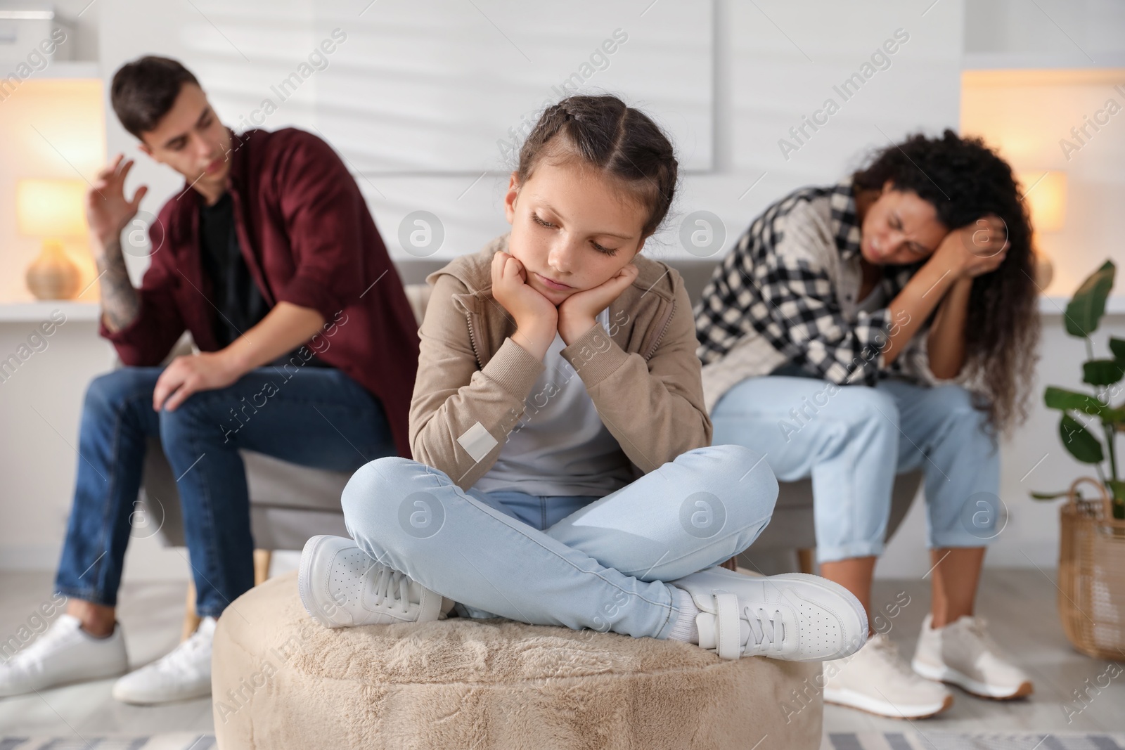 Photo of Divorce concept. Sad couple and their daughter at home