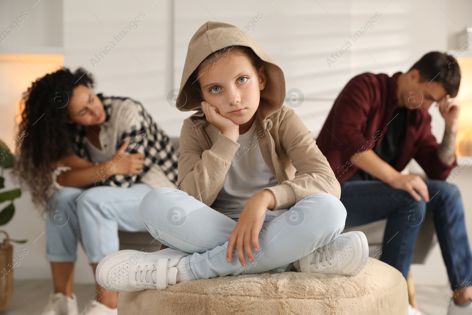 Photo of Divorce concept. Sad couple and their daughter at home