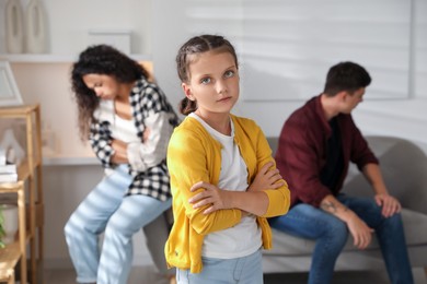 Photo of Divorce concept. Sad couple and their daughter at home