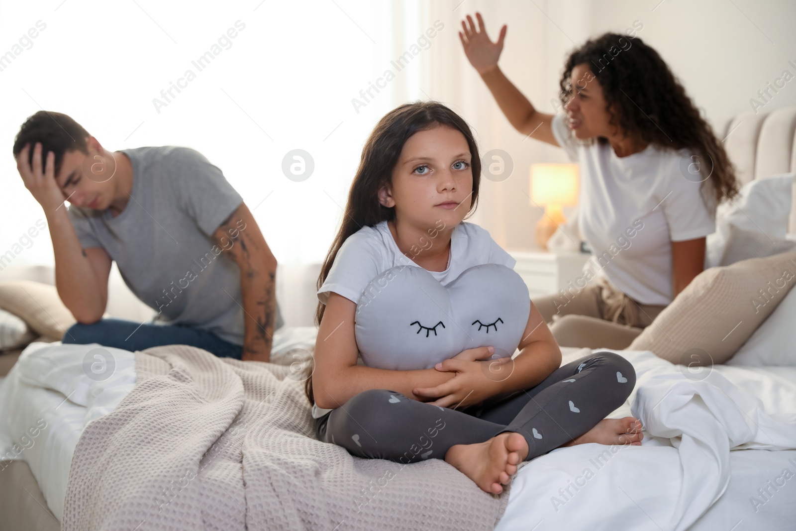 Photo of Divorce concept. Angry couple arguing in bedroom, focus on their sad daughter