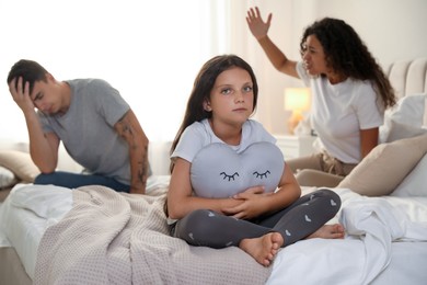 Photo of Divorce concept. Angry couple arguing in bedroom, focus on their sad daughter