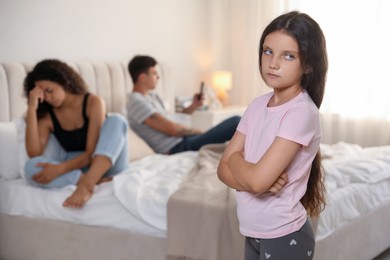 Photo of Divorce concept. Sad couple in bedroom, focus on their unhappy daughter