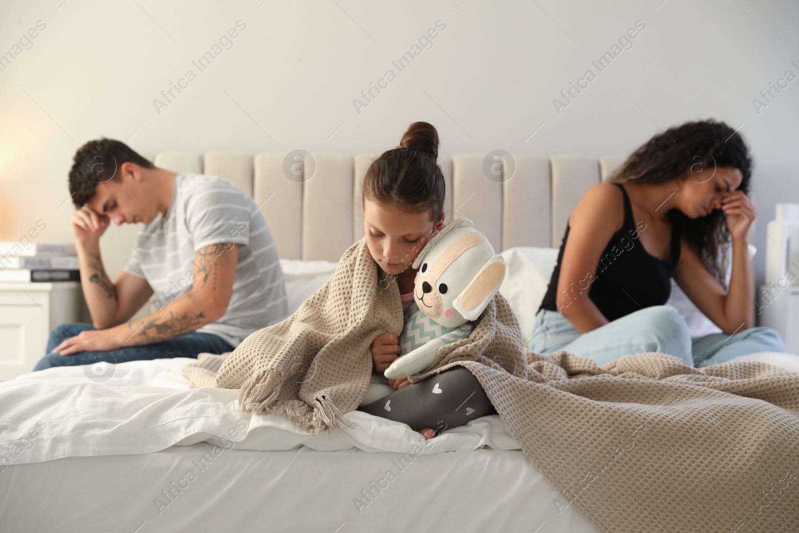 Photo of Divorce concept. Sad couple in bedroom, focus on their unhappy daughter