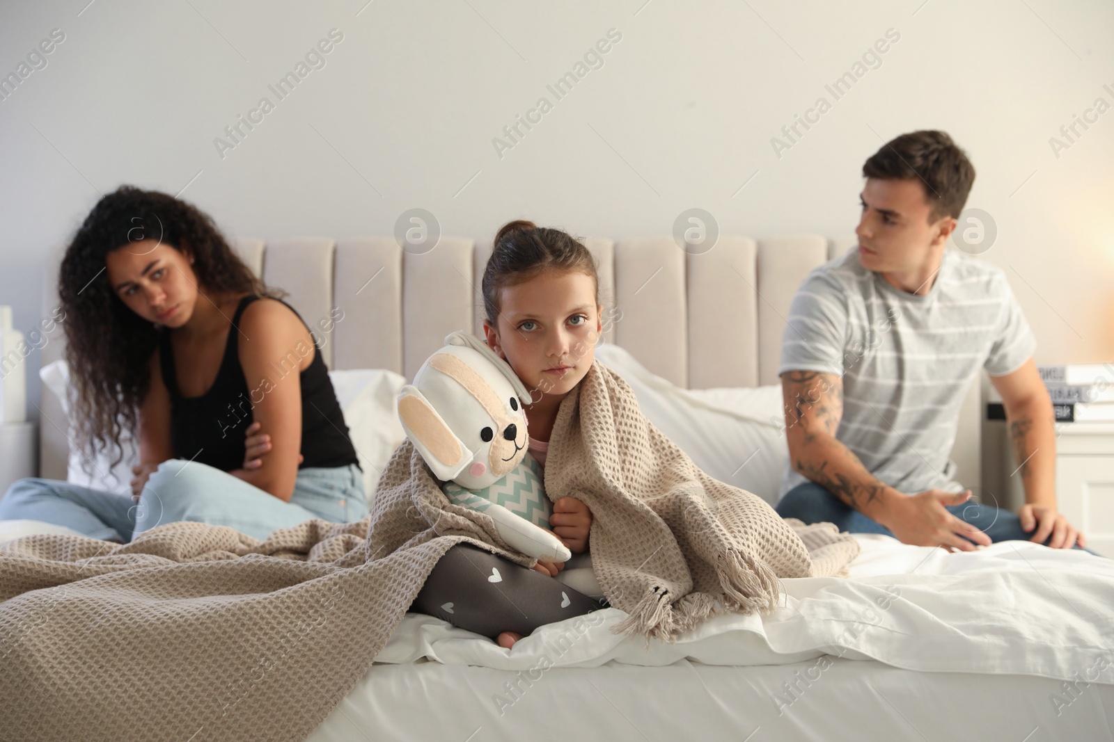 Photo of Divorce concept. Sad couple in bedroom, focus on their unhappy daughter