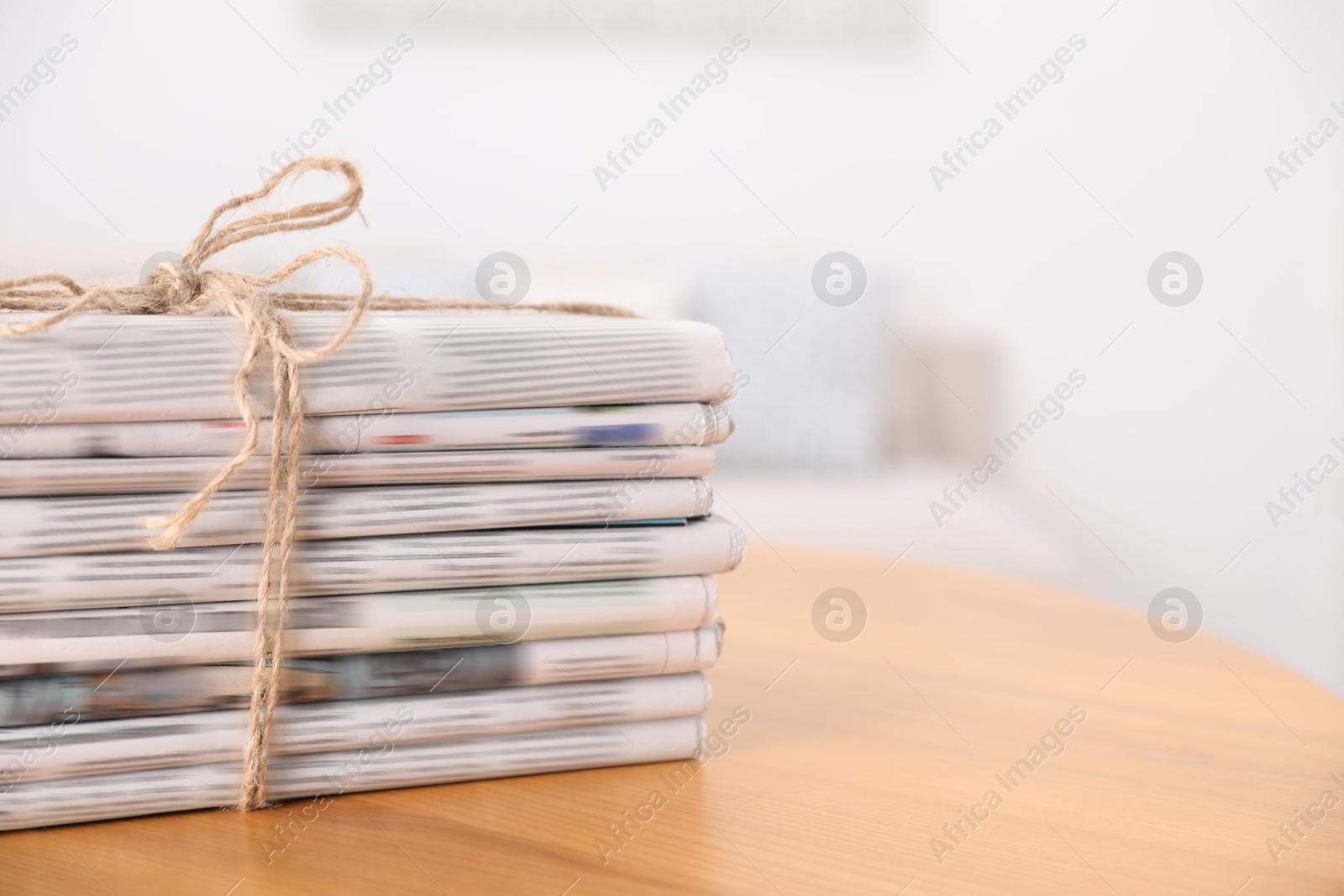 Photo of Stack of many newspapers in different languages on wooden table, space for text