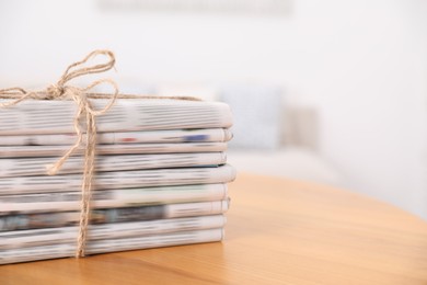 Photo of Stack of many newspapers in different languages on wooden table, space for text