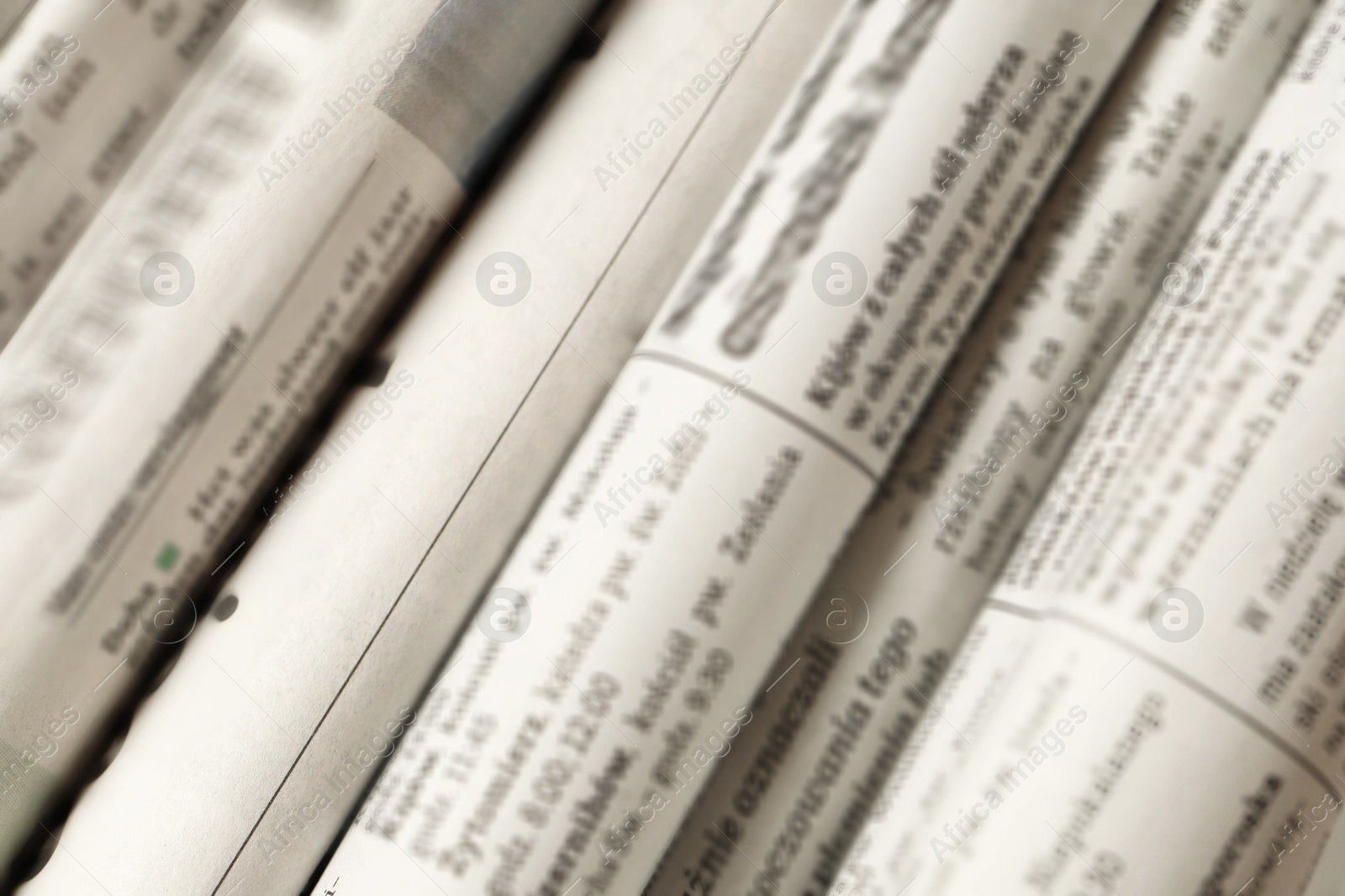 Photo of Many newspapers in different languages as background, closeup