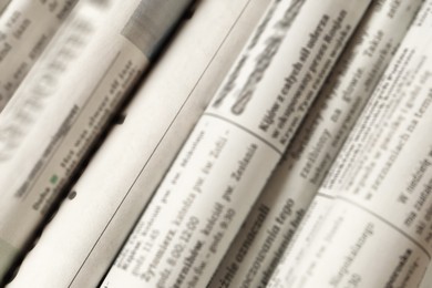 Photo of Many newspapers in different languages as background, closeup