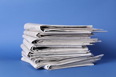 Photo of Stack of many newspapers on blue background