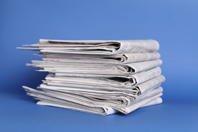 Stack of many newspapers on blue background