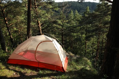 Photo of Modern camping tent in forest at summer, space for text