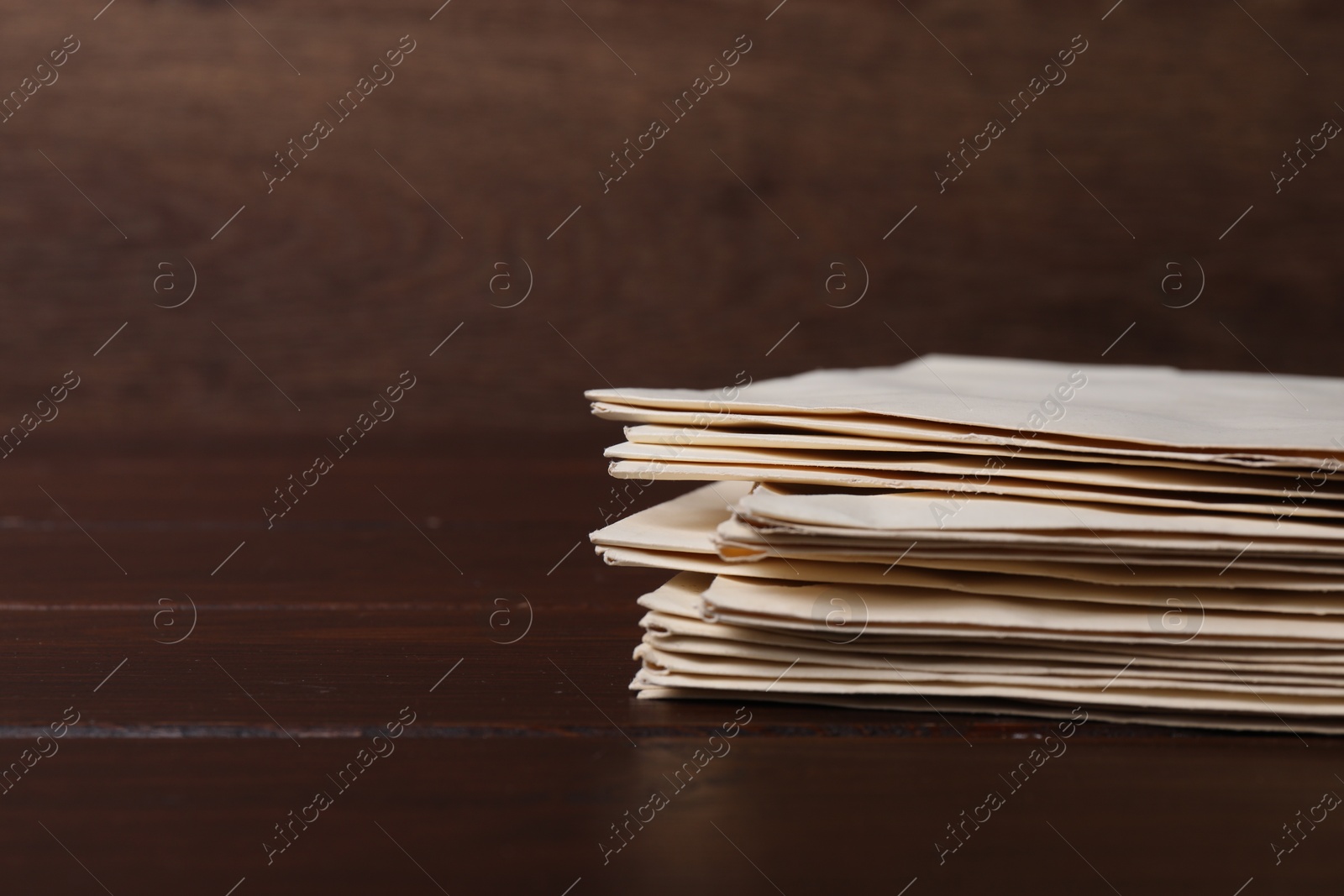 Photo of Stack of old letters on wooden table, closeup. Space for text