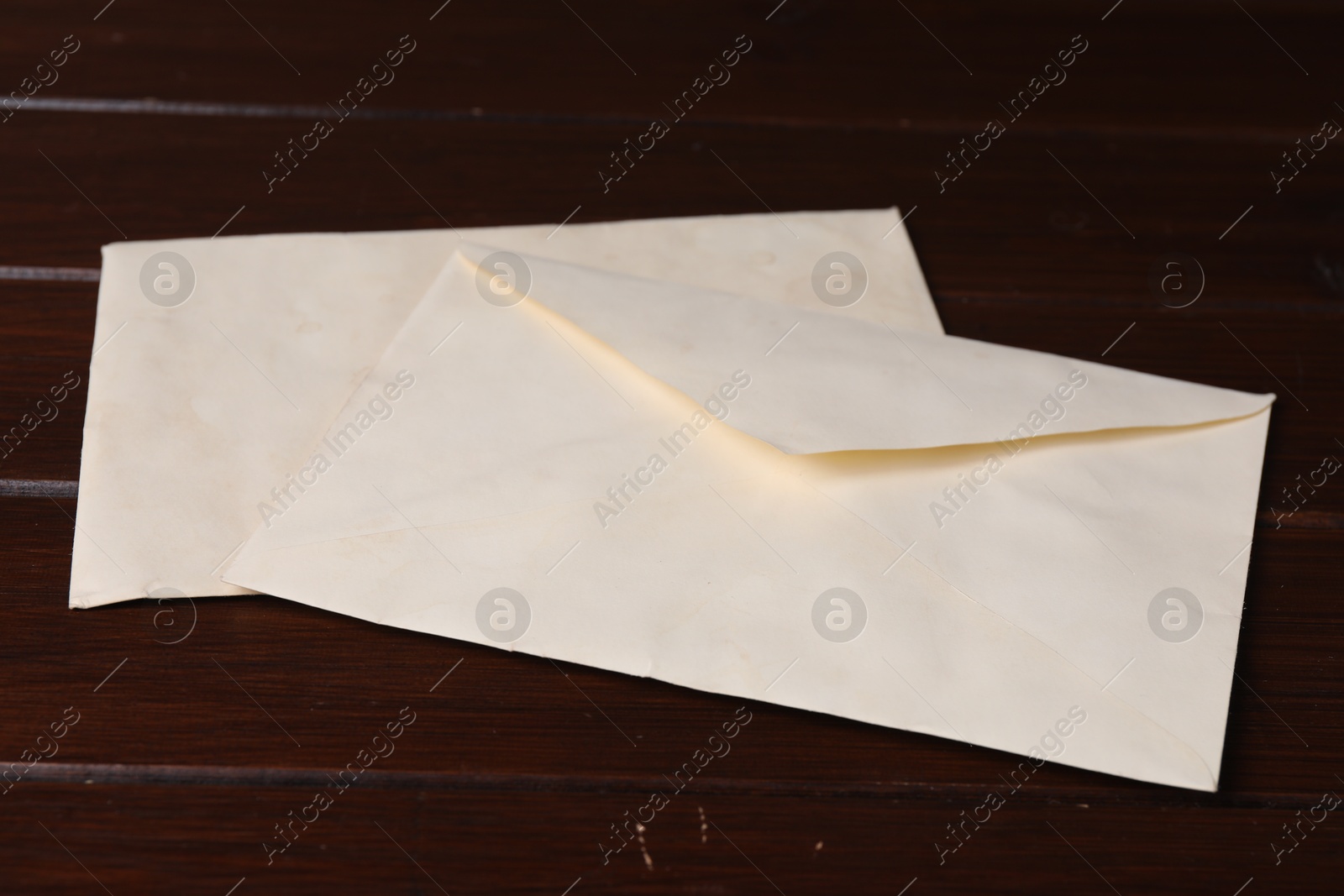 Photo of Old letter envelopes on wooden table, closeup