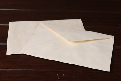 Old letter envelopes on wooden table, closeup