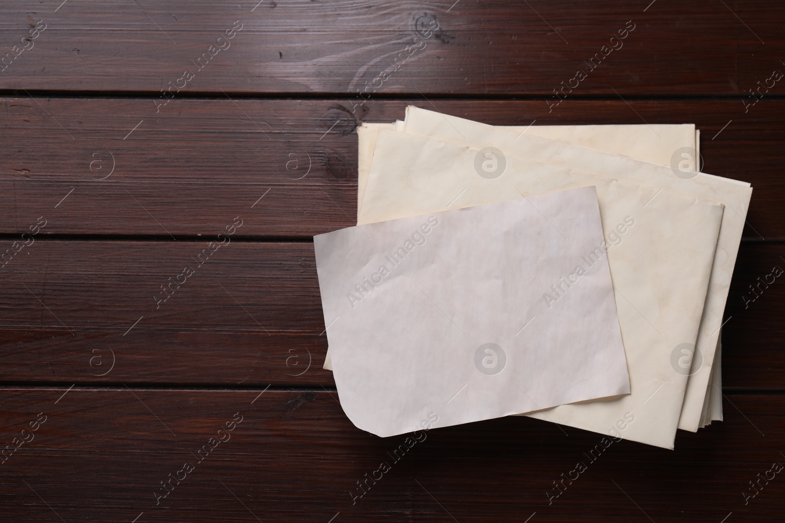 Photo of Old letter and envelopes on wooden table, top view. Space for text