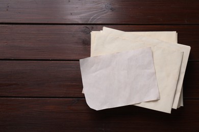 Photo of Old letter and envelopes on wooden table, top view. Space for text