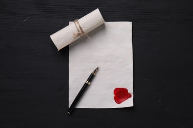 Old letters and fountain pen on black wooden table, top view