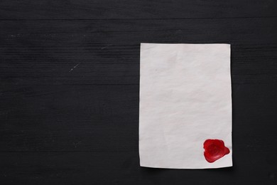 Photo of Blank old letter with wax stamp on black wooden table, top view. Space for text