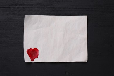 Blank old letter with wax stamp on black wooden table, top view