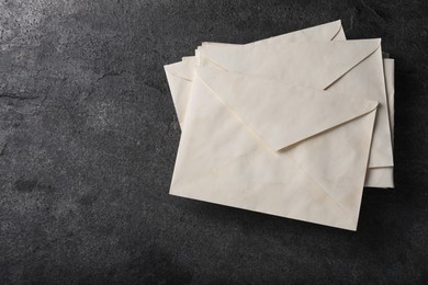 Photo of Old letter envelopes on grey table, top view. Space for text