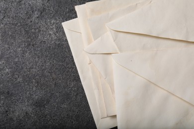 Old letter envelopes on grey table, top view. Space for text