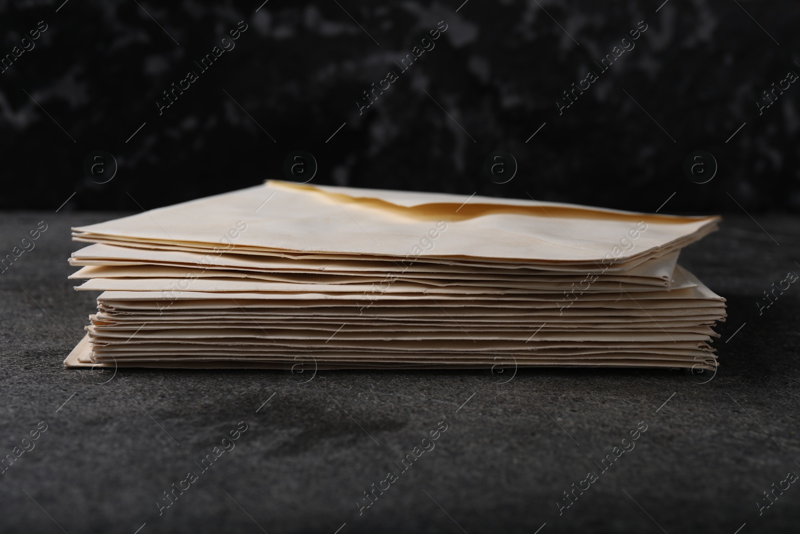 Photo of Stack of old letter envelopes on grey table, closeup