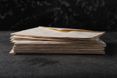 Photo of Stack of old letter envelopes on grey table, closeup