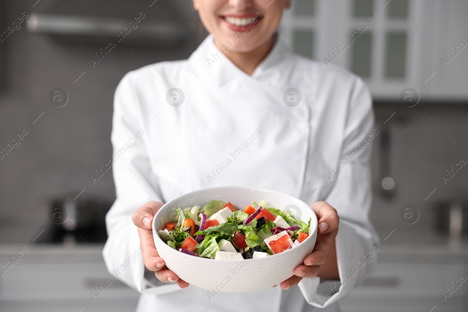 Photo of Professional chef with delicious salad in kitchen, closeup