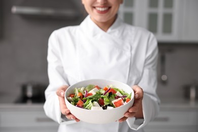 Photo of Professional chef with delicious salad in kitchen, closeup