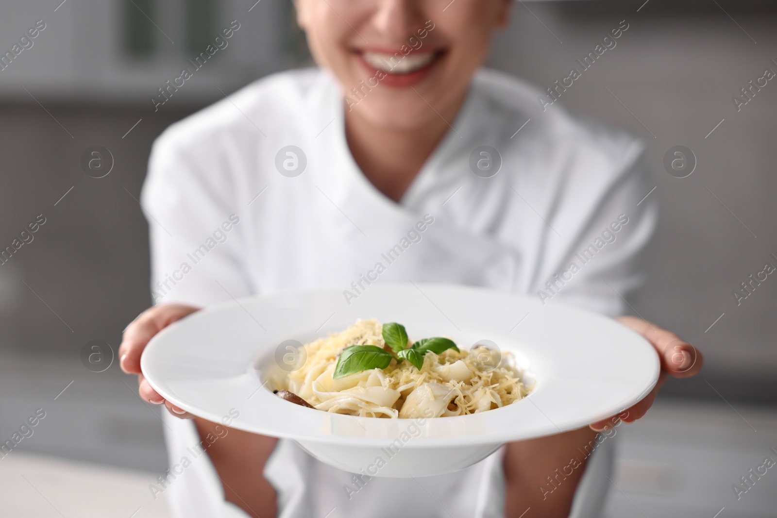 Photo of Professional chef with delicious pasta in kitchen, closeup