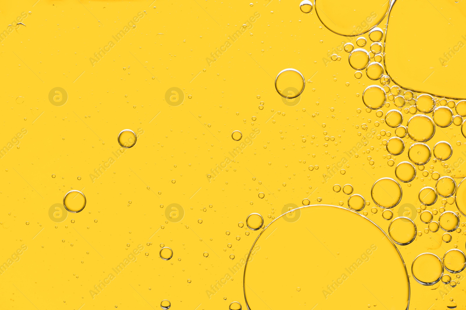 Photo of Sample of cosmetic oil on yellow background, macro view