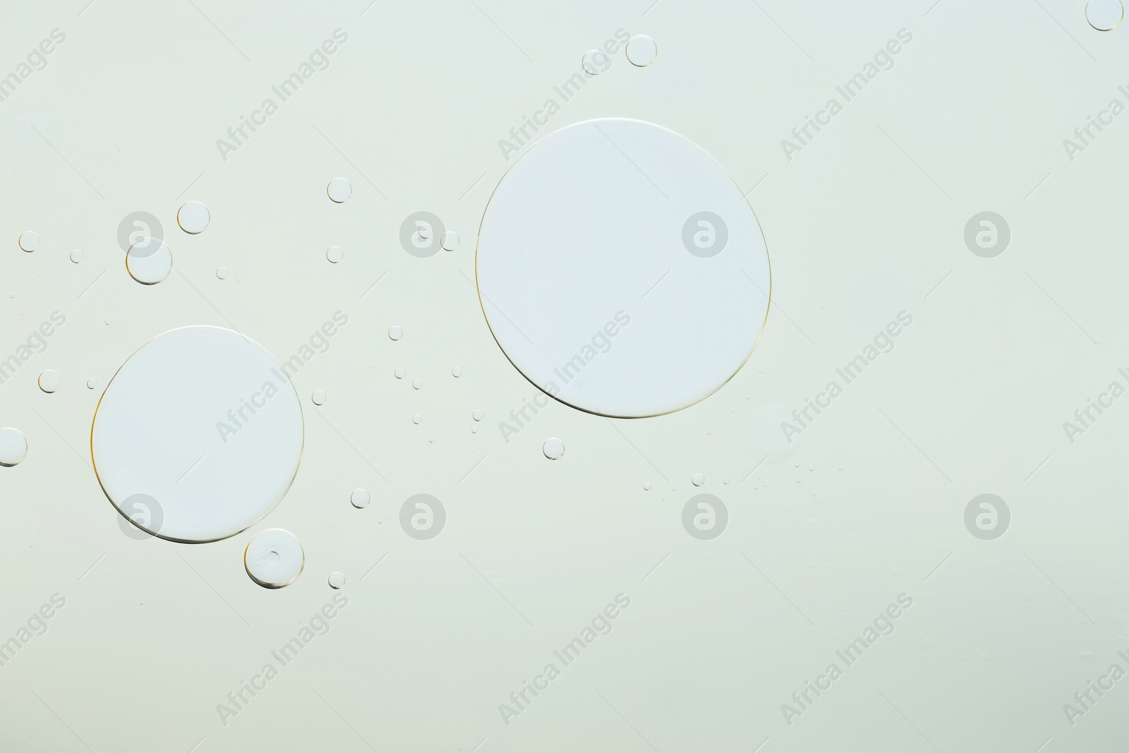 Photo of Sample of cosmetic oil on light grey background, macro view