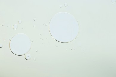 Photo of Sample of cosmetic oil on light grey background, macro view