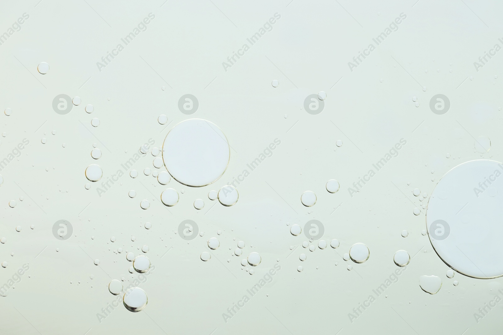 Photo of Sample of cosmetic oil on light grey background, macro view