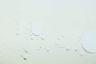 Photo of Sample of cosmetic oil on light grey background, macro view