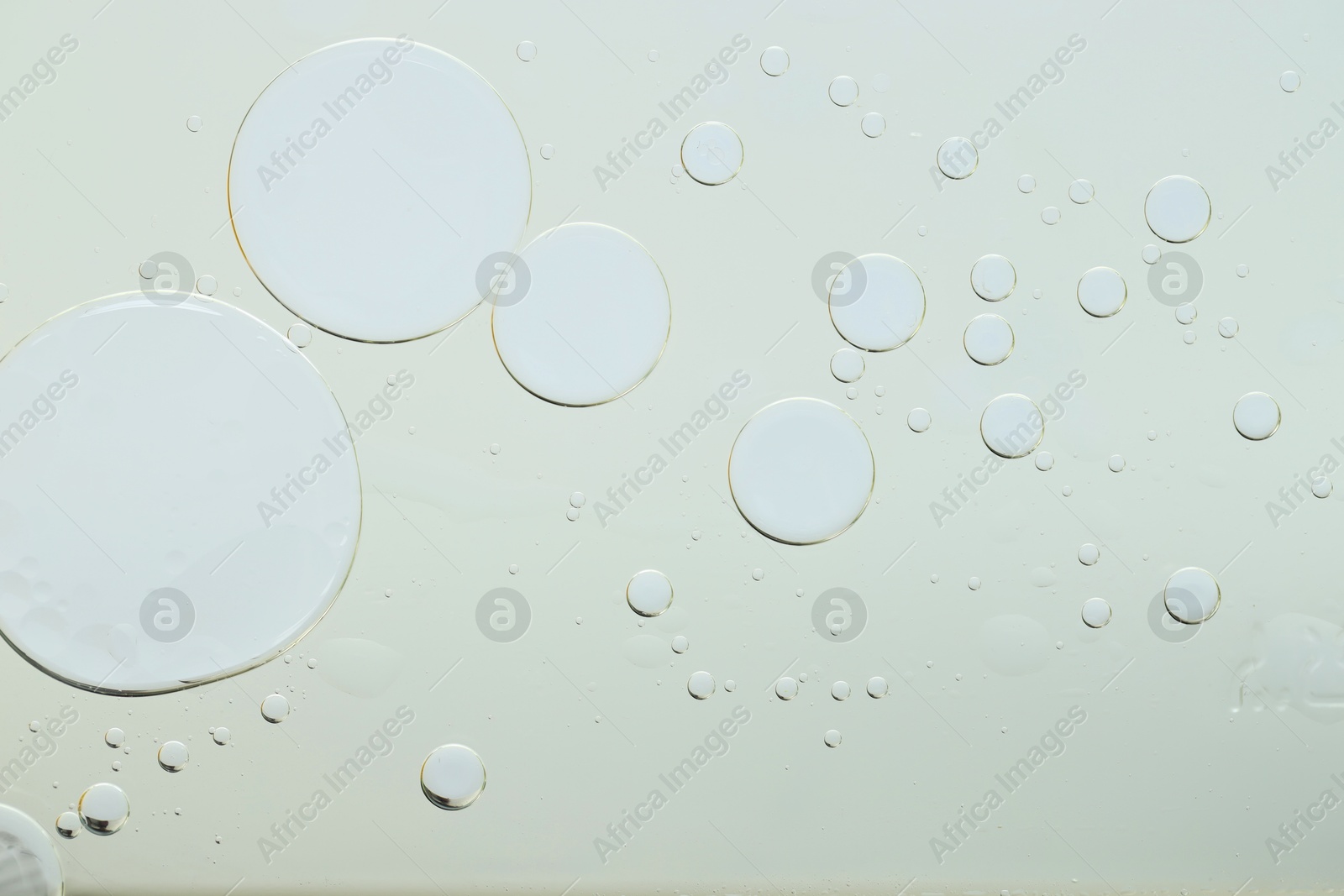 Photo of Sample of cosmetic oil on light grey background, macro view