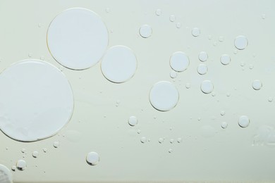 Photo of Sample of cosmetic oil on light grey background, macro view