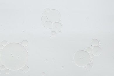 Essential oil bubbles on white background, macro view. Cosmetic product