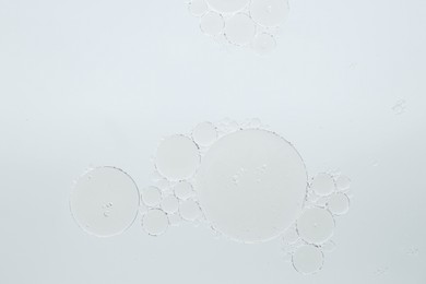 Essential oil bubbles on white background, macro view. Cosmetic product