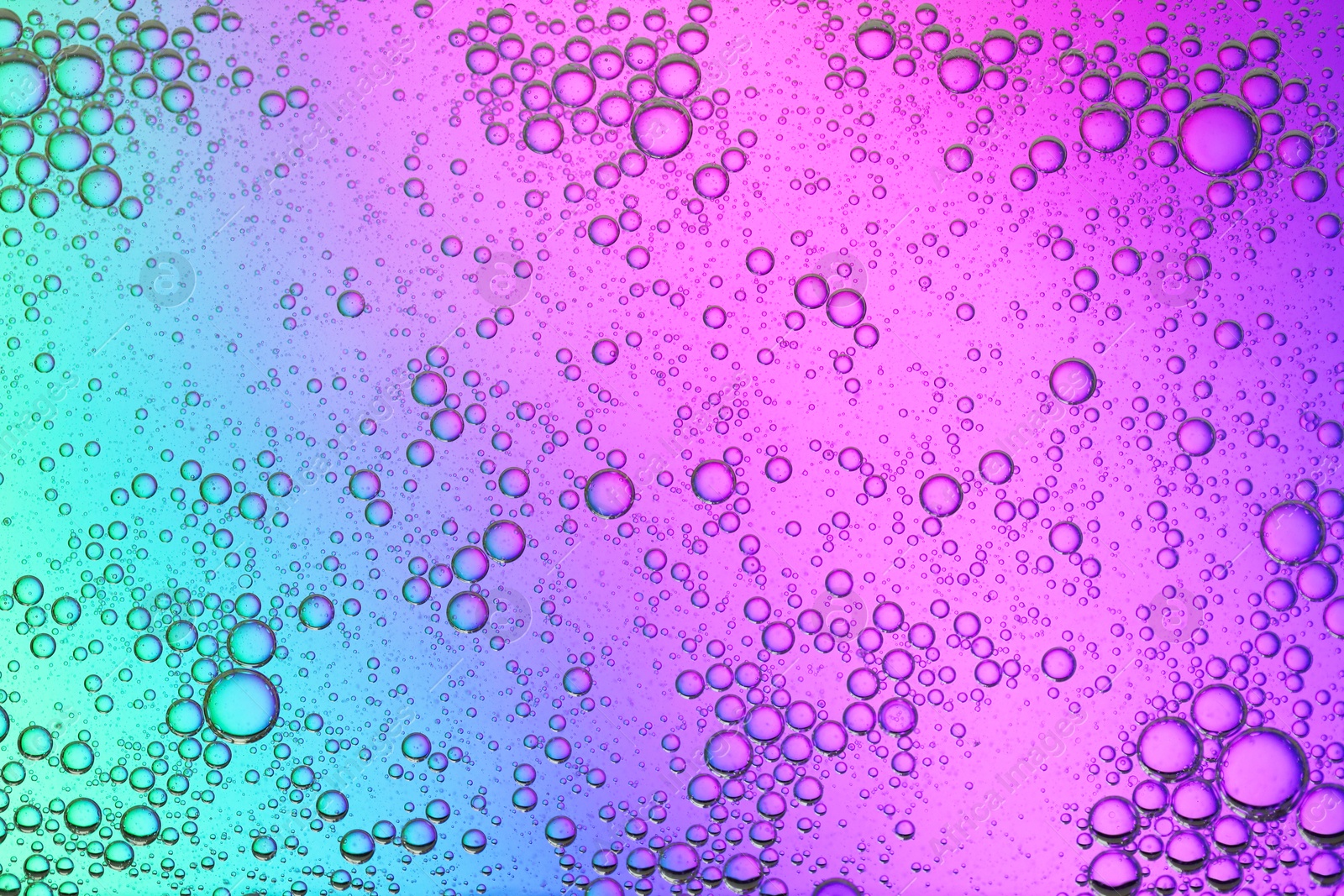 Photo of Essential oil bubbles on color background, macro view. Cosmetic product