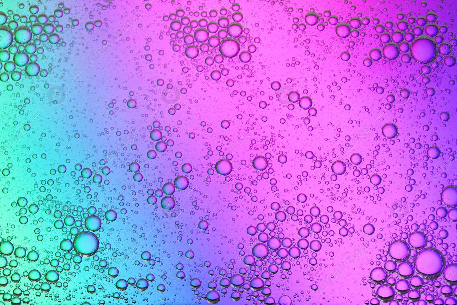 Photo of Essential oil bubbles on color background, macro view. Cosmetic product