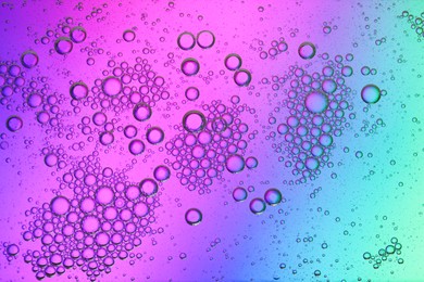 Essential oil bubbles on color background, macro view. Cosmetic product