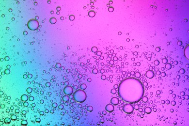 Photo of Essential oil bubbles on color background, macro view. Cosmetic product