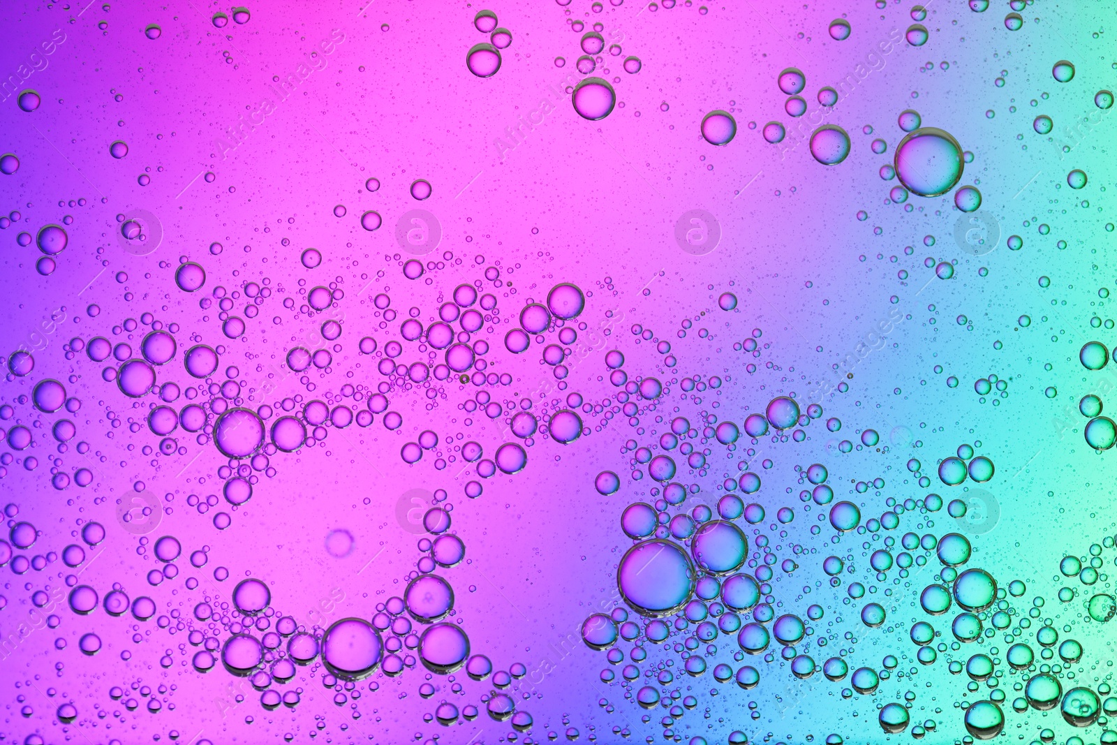 Photo of Essential oil bubbles on color background, macro view. Cosmetic product