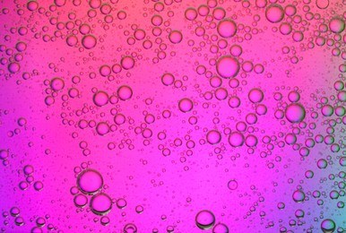 Photo of Essential oil bubbles on color background, macro view. Cosmetic product