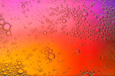 Photo of Essential oil bubbles on color background, macro view. Cosmetic product