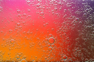 Essential oil bubbles on color background, macro view. Cosmetic product