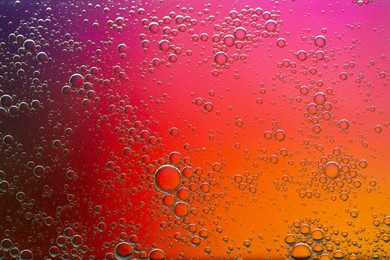 Photo of Essential oil bubbles on color background, macro view. Cosmetic product