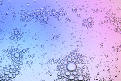 Photo of Essential oil bubbles on color background, macro view. Cosmetic product