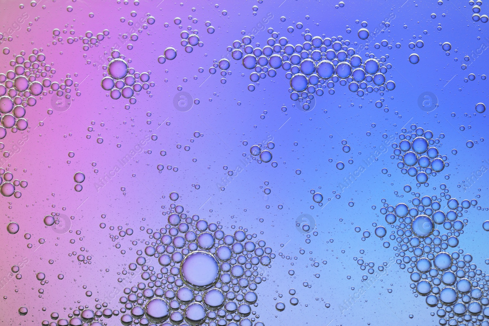 Photo of Essential oil bubbles on color background, macro view. Cosmetic product